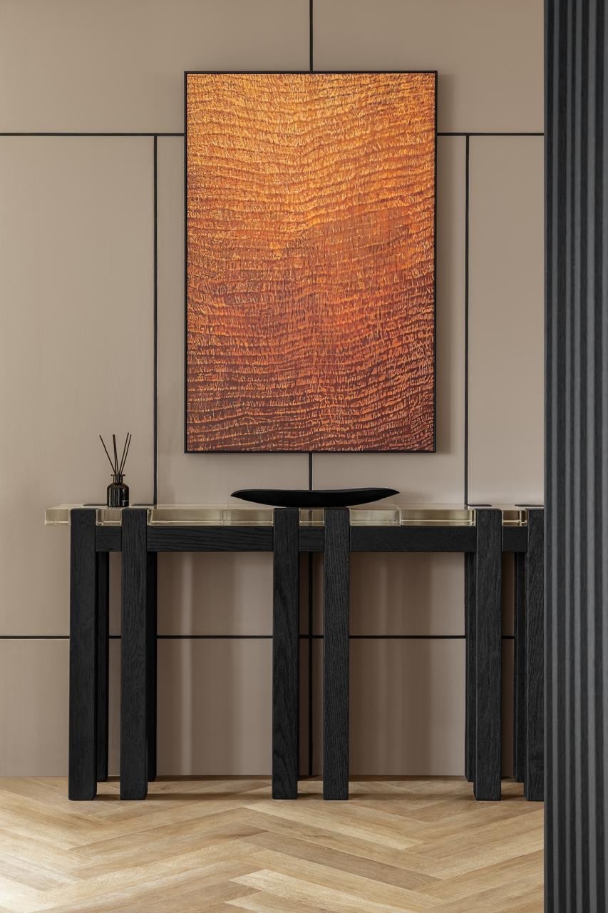Entryway console table with an abstract wood-grain artwork above it, in warm terracotta and black tones